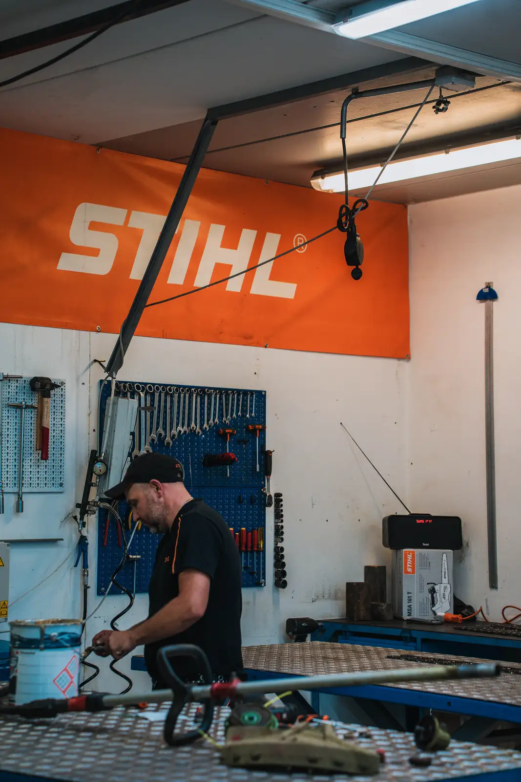 Mechaniker in der Werkstatt der Illmer Karl GmbH in Lana unter dem STIHL-Banner